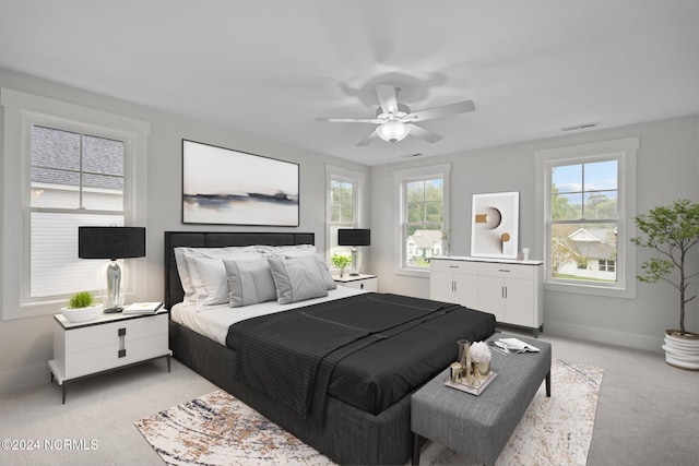 carpeted bedroom featuring ceiling fan and multiple windows