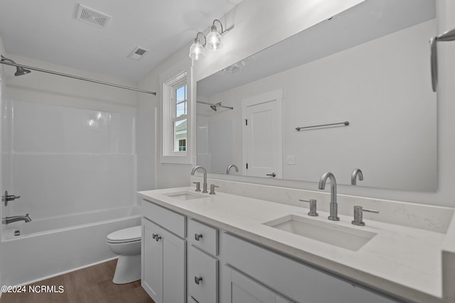 full bathroom with shower / bathtub combination, hardwood / wood-style floors, toilet, and vanity