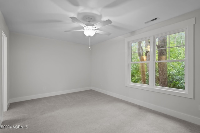 carpeted spare room featuring ceiling fan