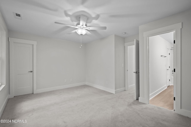 unfurnished room with ceiling fan and light colored carpet