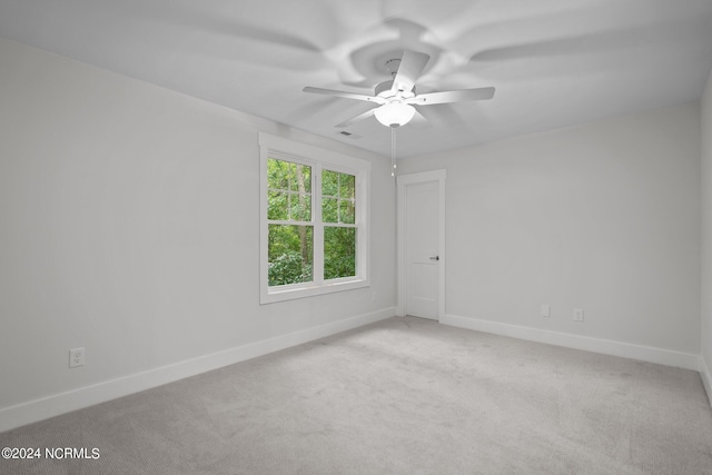 spare room featuring light carpet and ceiling fan