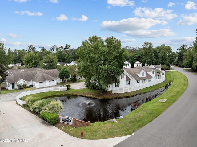 surrounding community with a water view and a yard