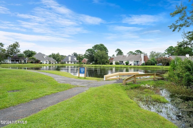 view of home's community featuring a water view and a yard