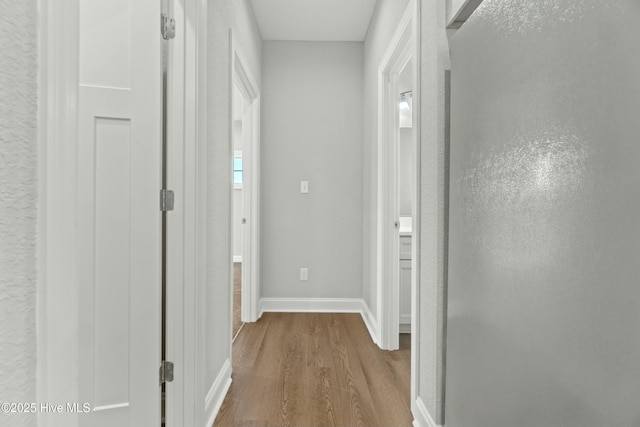 corridor with hardwood / wood-style flooring