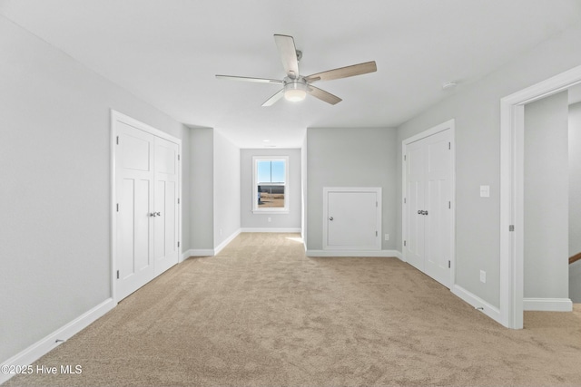 interior space featuring light carpet and ceiling fan