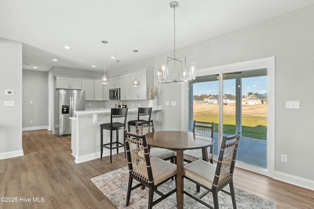 dining space with a notable chandelier and hardwood / wood-style flooring