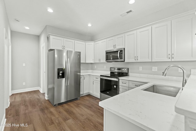 kitchen with sink, light stone counters, appliances with stainless steel finishes, dark hardwood / wood-style floors, and white cabinets