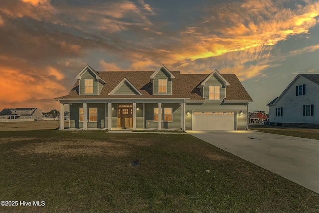 cape cod home with a garage, a yard, and covered porch