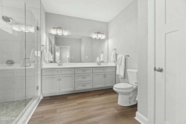 bathroom with walk in shower, vanity, toilet, and hardwood / wood-style floors