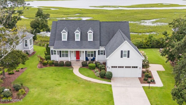 cape cod house with a garage, a porch, and a front lawn