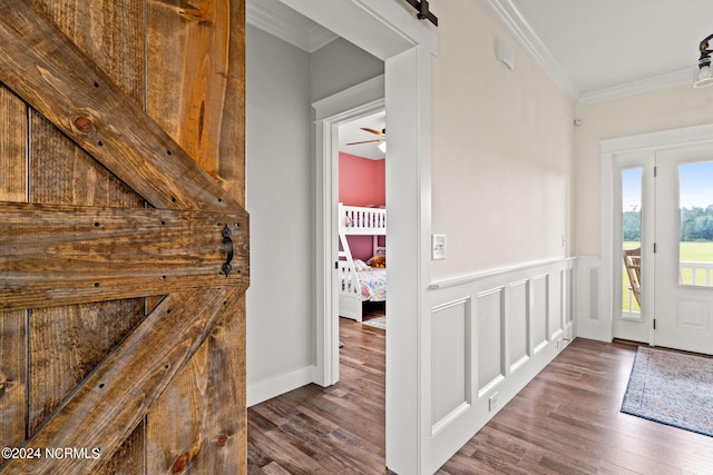 entrance foyer featuring crown molding, dark wood-type flooring, and a barn door