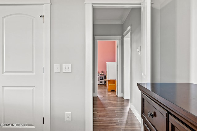 corridor with crown molding and dark wood-type flooring