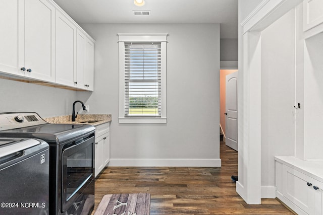 washroom featuring cabinets, independent washer and dryer, dark wood-type flooring, and sink