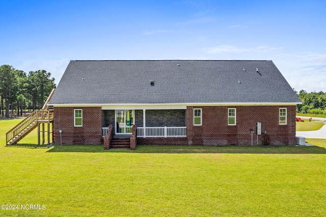 rear view of property with cooling unit and a lawn