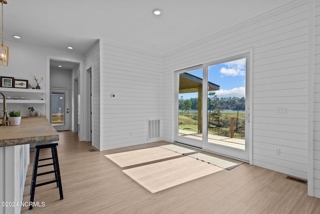 interior space featuring light wood-type flooring and wooden walls