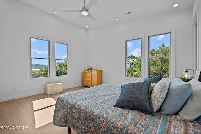 bedroom featuring multiple windows, ceiling fan, and light hardwood / wood-style flooring