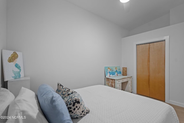 bedroom featuring ceiling fan, a closet, hardwood / wood-style floors, and vaulted ceiling