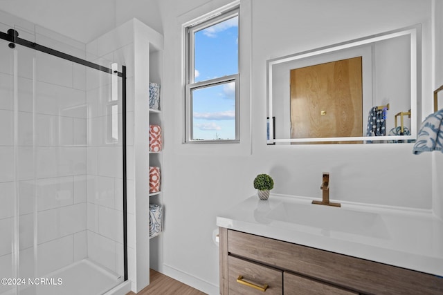 bathroom featuring vanity, wood-type flooring, and a shower with door