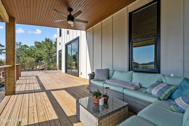 wooden deck with an outdoor living space and ceiling fan