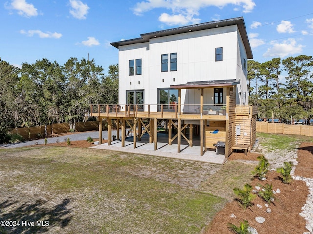 back of house with a wooden deck and a patio area