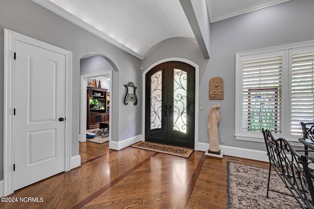 foyer with arched walkways, french doors, baseboards, and wood finished floors