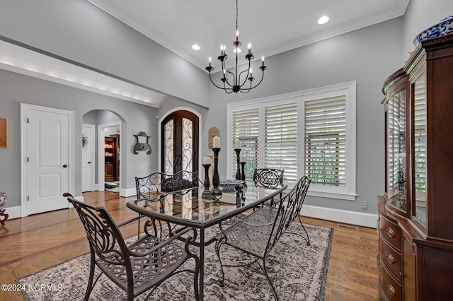 dining area with baseboards, arched walkways, ornamental molding, wood finished floors, and recessed lighting