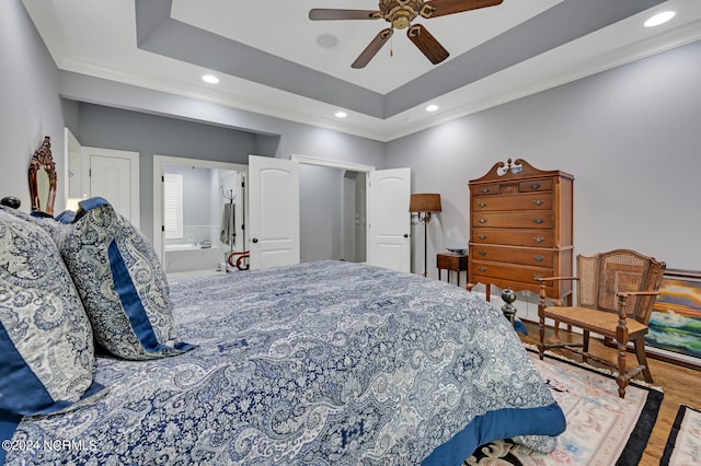 bedroom featuring recessed lighting, a raised ceiling, and wood finished floors