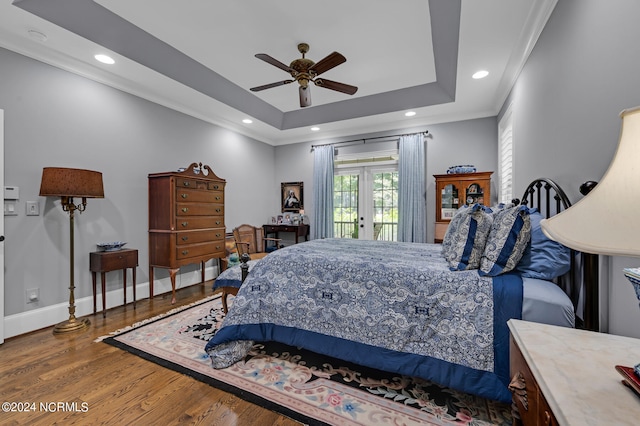 bedroom with wood finished floors, baseboards, access to exterior, french doors, and a tray ceiling