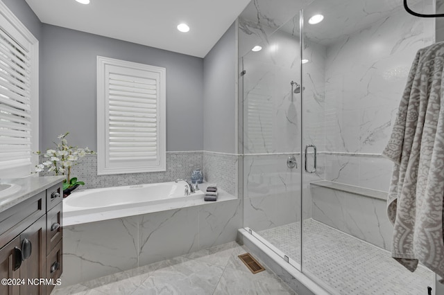 bathroom with a garden tub, a marble finish shower, recessed lighting, visible vents, and vanity