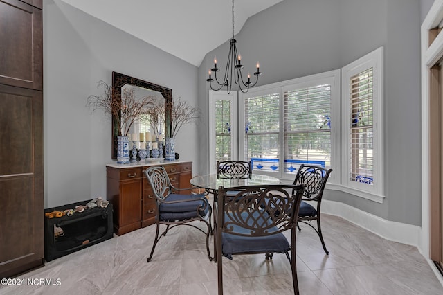 dining room with lofted ceiling, baseboards, and an inviting chandelier