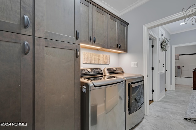 washroom featuring marble finish floor, ornamental molding, independent washer and dryer, and cabinet space