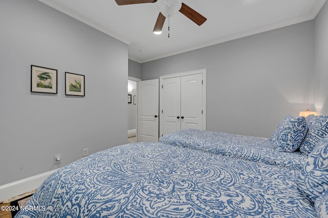 bedroom with a ceiling fan, baseboards, ornamental molding, and a closet