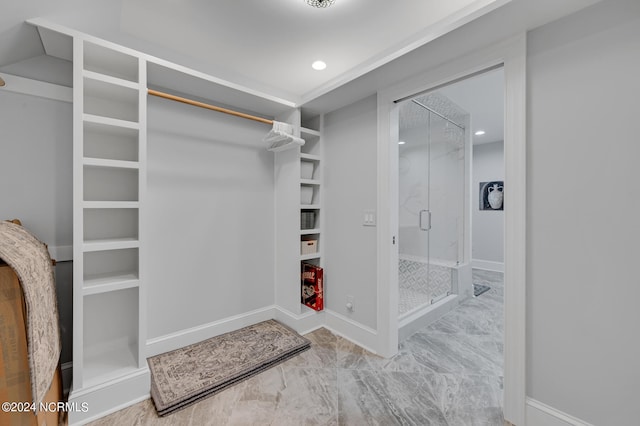 walk in closet featuring marble finish floor