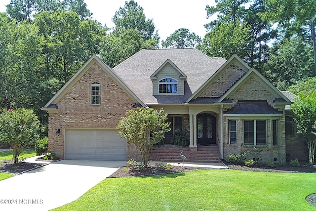 view of front of property with a garage, brick siding, driveway, and a front lawn