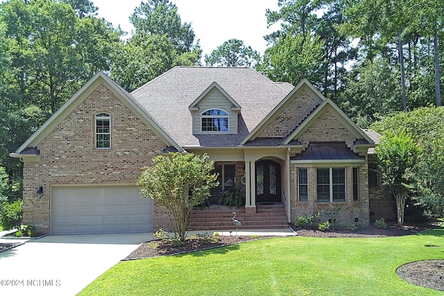 view of front of house with a garage, driveway, a front lawn, and brick siding