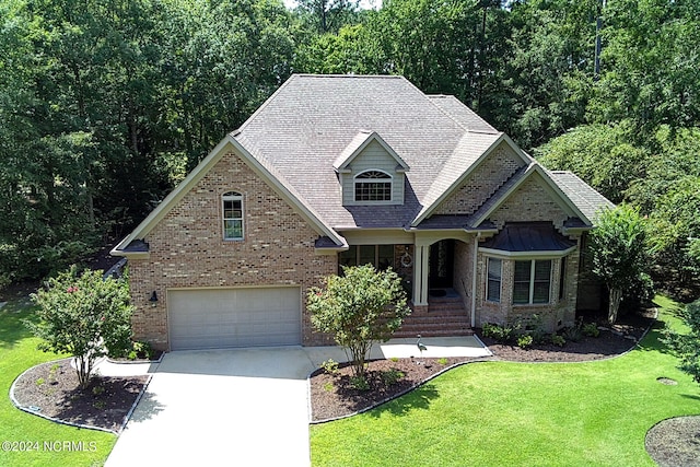 view of front of home featuring driveway, a front lawn, an attached garage, and brick siding