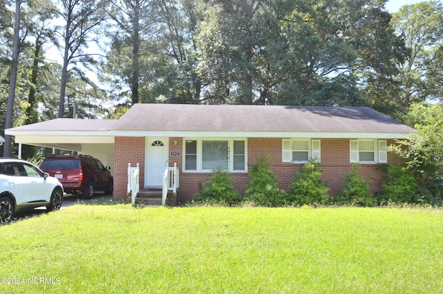 ranch-style home featuring a carport, a front yard, and brick siding