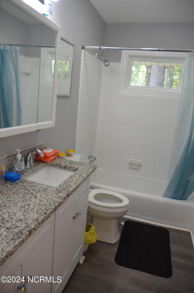 full bathroom featuring shower / bath combo with shower curtain, vanity, hardwood / wood-style floors, and toilet