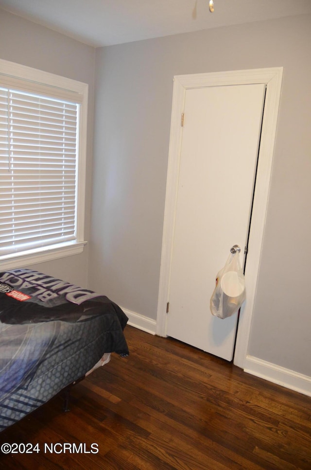 bedroom featuring baseboards and wood finished floors