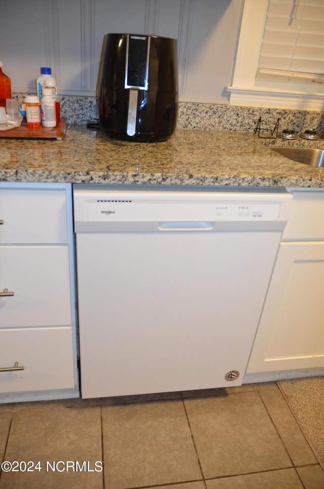 kitchen featuring tile patterned flooring, white cabinetry, white dishwasher, and light stone countertops