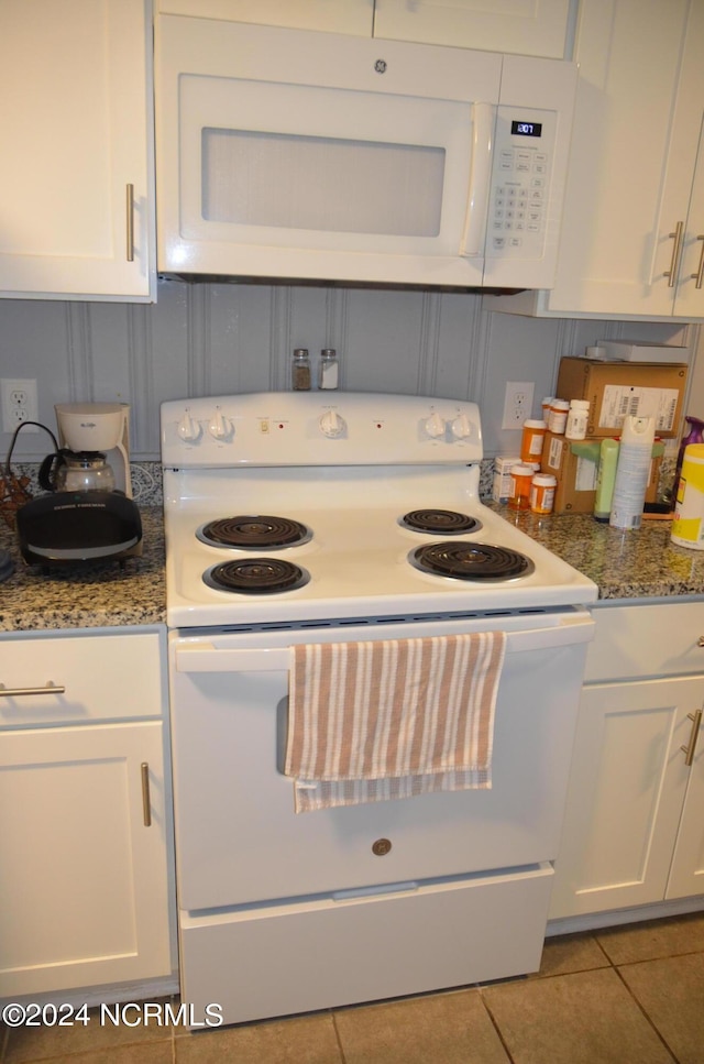 kitchen featuring white appliances, tile patterned flooring, white cabinetry, and light stone countertops