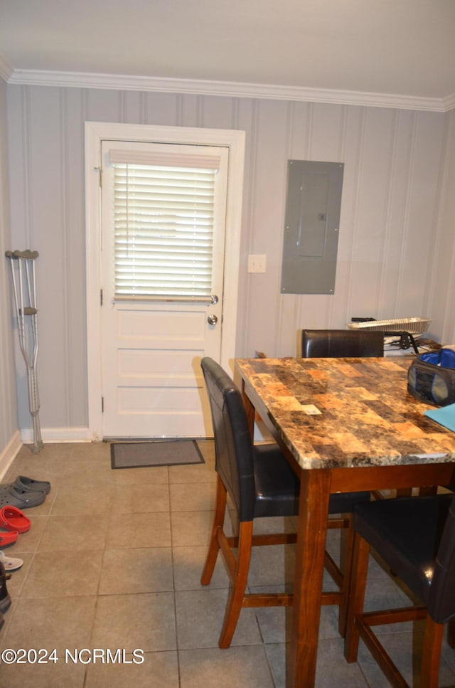 tiled dining area featuring electric panel and ornamental molding