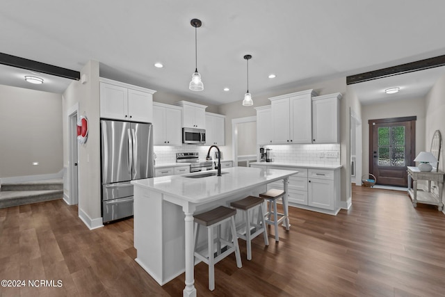 kitchen featuring stainless steel appliances, white cabinetry, sink, an island with sink, and dark wood-type flooring