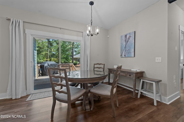 dining area with dark wood-type flooring and a chandelier