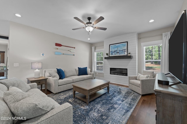 living room with a fireplace, ceiling fan, and dark hardwood / wood-style floors