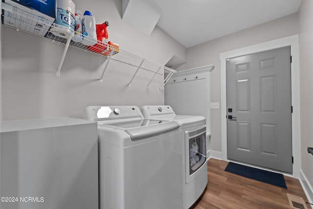 laundry area with independent washer and dryer and light hardwood / wood-style floors