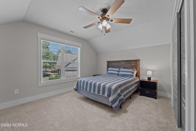 carpeted bedroom with ceiling fan and vaulted ceiling