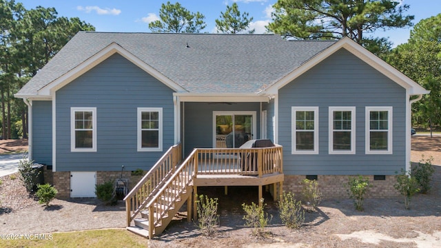 rear view of property featuring a wooden deck