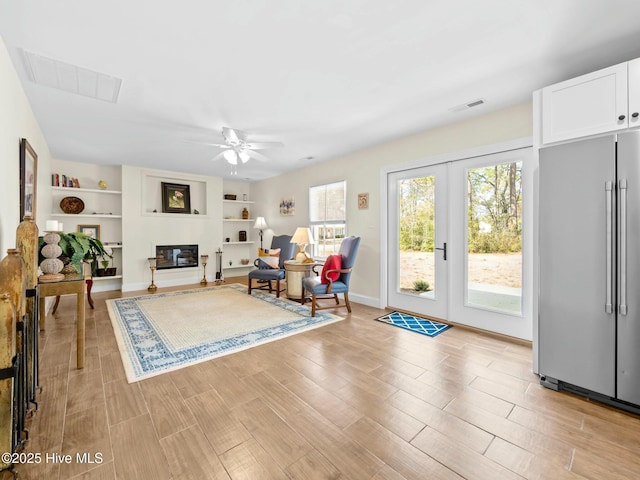 sitting room with light wood-type flooring, visible vents, and a ceiling fan