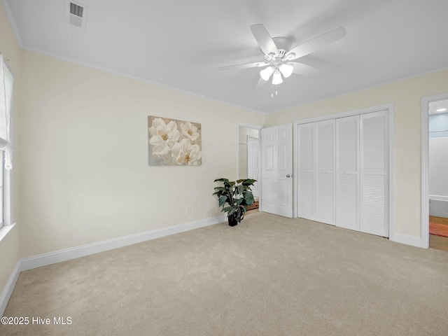 unfurnished bedroom featuring visible vents, carpet, a closet, and baseboards